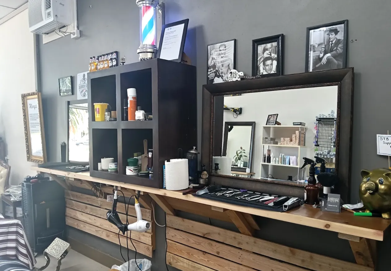 Inside the shop: barber pole, mirror station and framed black and white photos on the wall